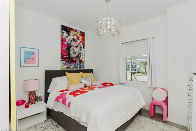 a bedroom with a bed and a chandelier