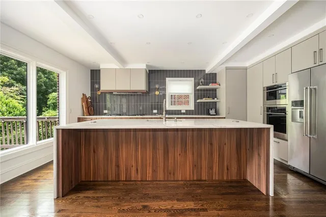a kitchen with stainless steel appliances granite countertop a refrigerator and a stove