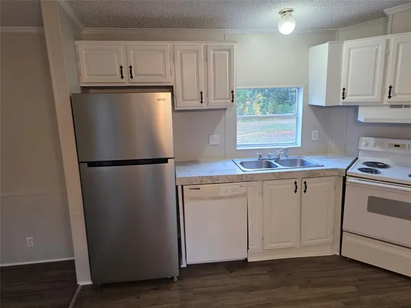 a kitchen with white cabinets and white appliances