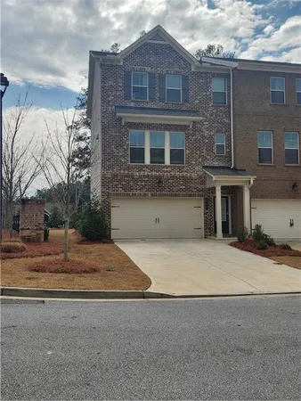 a front view of a house with yard and trees