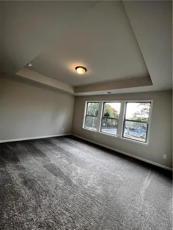 an empty room with a fireplace and large windows