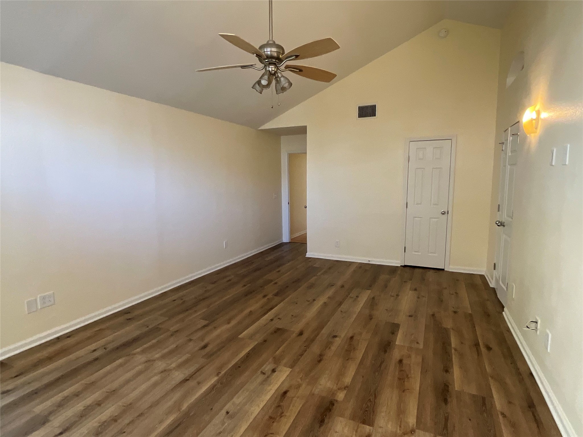 15702 Racine Cove Austin, TX 78717 - Photo 18 of 27 A well-lit interior features vaulted ceilings and rich wood-style flooring.
