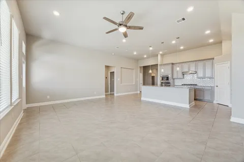 a view of an empty room and kitchen view