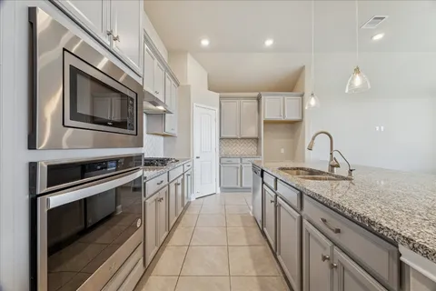 a kitchen with stainless steel appliances granite countertop a sink and stove top oven