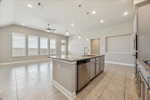 a large kitchen with stainless steel appliances granite countertop a large counter top and a stove