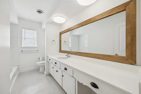a bathroom with a double vanity sink mirror and toilet