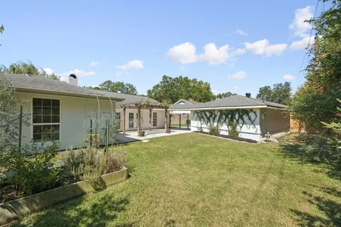 a view of a house with yard and sitting area