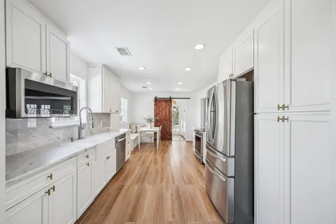 a kitchen with stainless steel appliances granite countertop a refrigerator and a sink