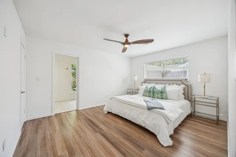 a bedroom with a large bed chandelier and a window