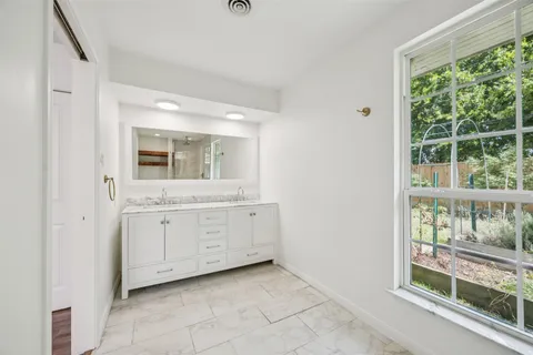 a spacious bathroom with a double vanity sink and a mirror