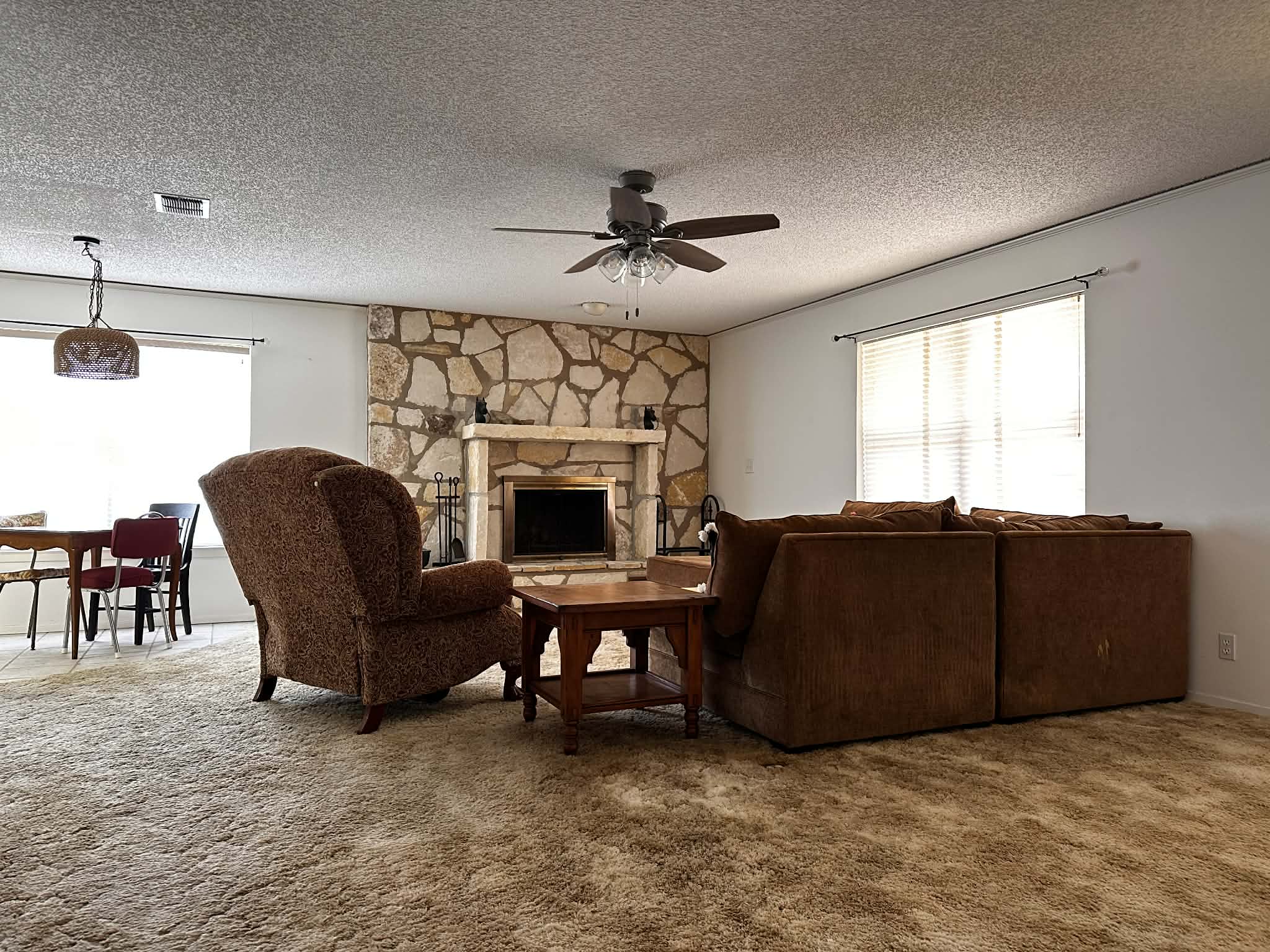 810 Kc 271 Junction Junction, TX 76849 - Photo 20 of 20 Carpeted living area with a fireplace, a textured ceiling, and ceiling fan