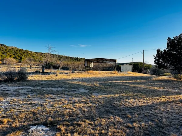 a view of a big yard with a house in the background