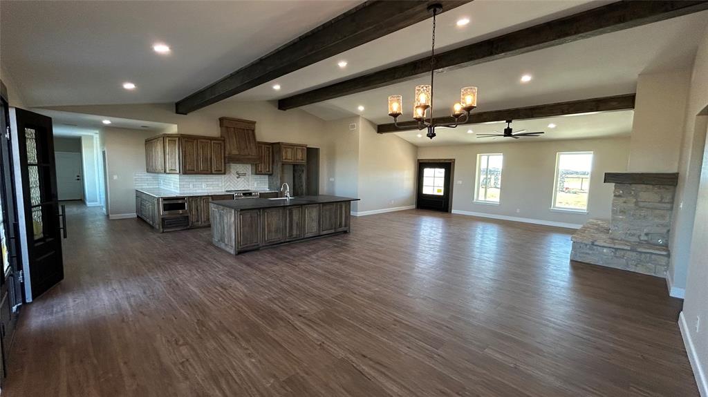 8740 Star Hollow Road Lipan, TX 76462 - Photo 3 of 40 a open kitchen with stainless steel appliances granite countertop a refrigerator a stove and a wooden floors