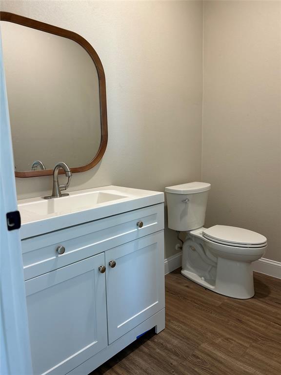 8740 Star Hollow Road Lipan, TX 76462 - Photo 31 of 40 a bathroom with a toilet a sink and wooden floor