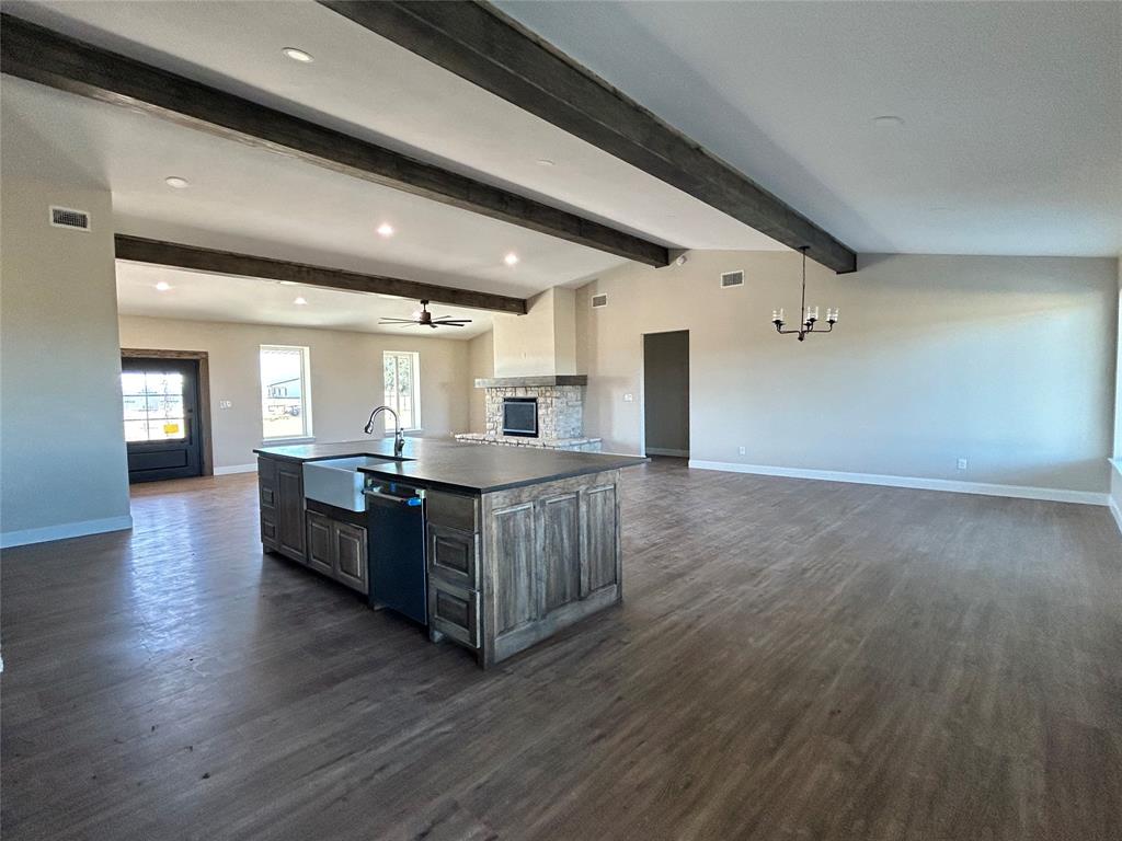 8740 Star Hollow Road Lipan, TX 76462 - Photo 34 of 40 a kitchen with stainless steel appliances kitchen island wooden floors and view living room