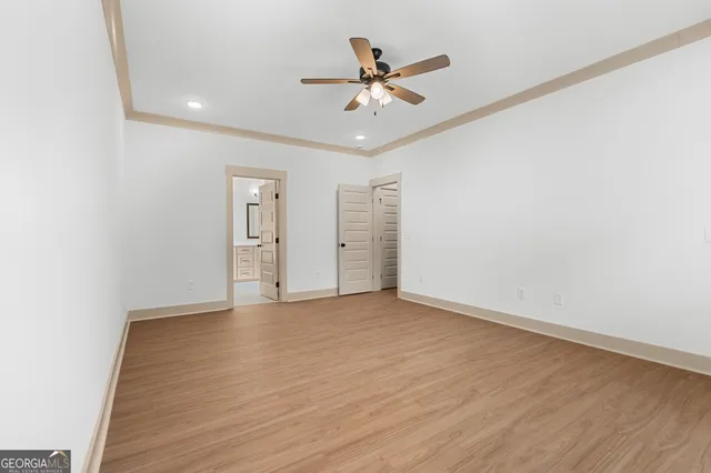 an empty room with closet and fan