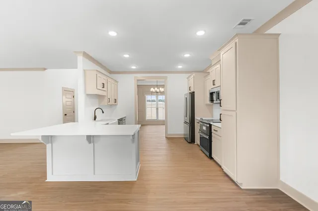 a view of a kitchen with a sink a refrigerator and a stove top oven