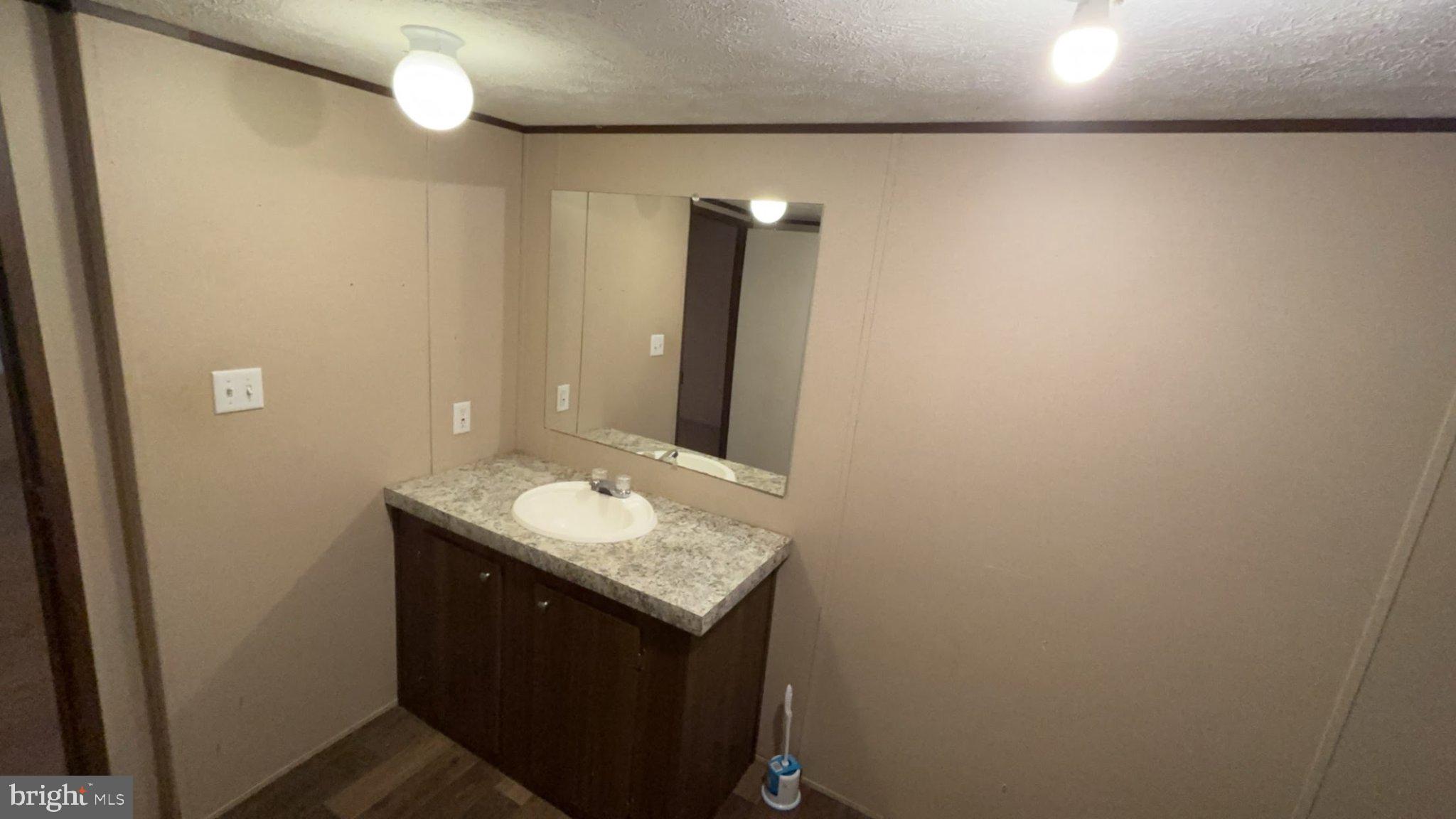 8510 Darcy Lane Partlow, VA 22534 - Photo 4 of 27 a bathroom with a granite countertop sink and a mirror