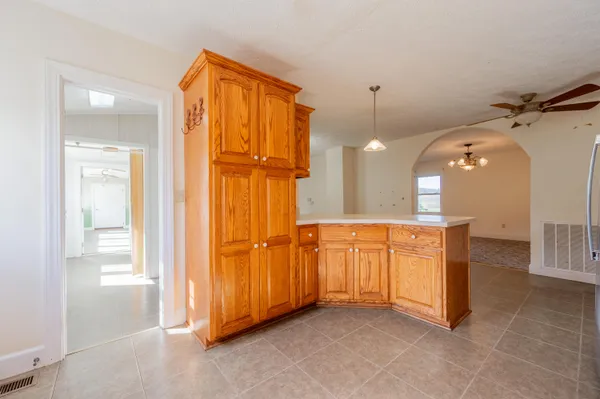 a view of a hallway with wooden floor and a chandelier
