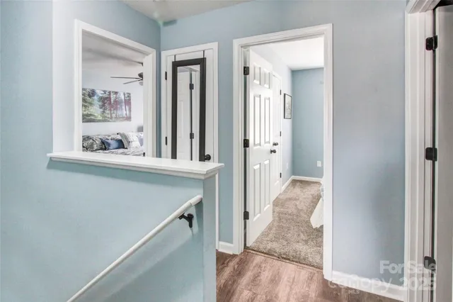 a view of a hallway with wooden floor and staircase