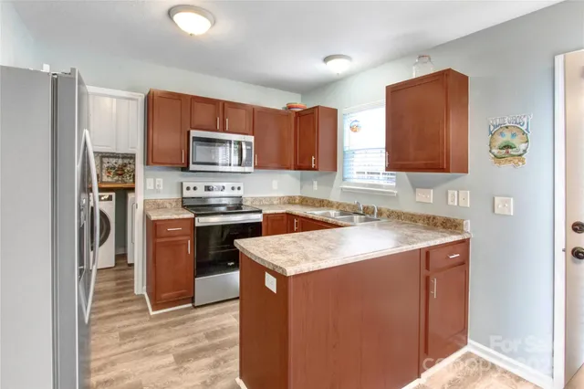 a kitchen with granite countertop stainless steel appliances and wooden cabinets