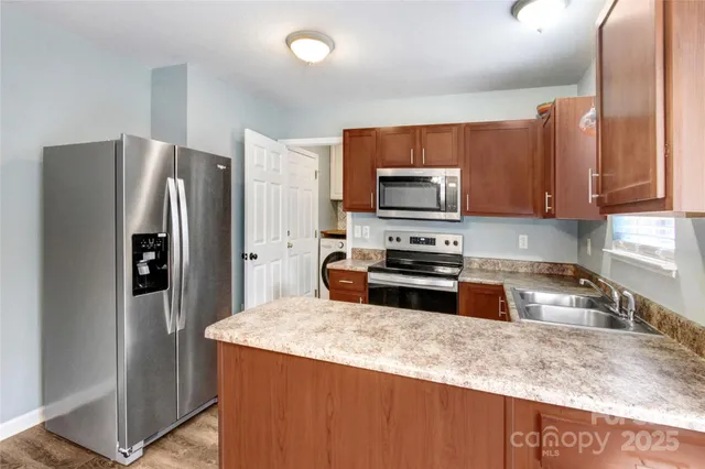 a kitchen with granite countertop a refrigerator and a sink