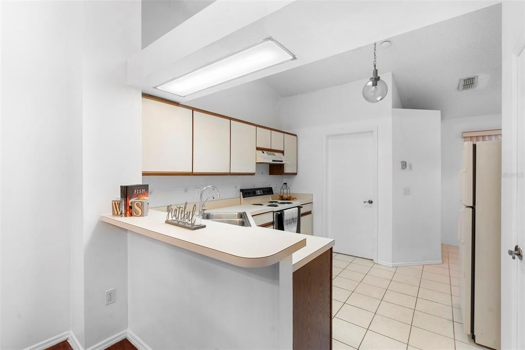 13103 Edberg Court Orlando, FL 32824 - Photo 20 of 42 a kitchen with a sink a stove a refrigerator and cabinets
