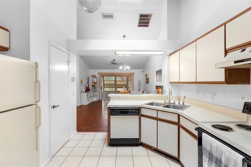 13103 Edberg Court Orlando, FL 32824 - Photo 23 of 42 a kitchen with a sink a stove a refrigerator and cabinets