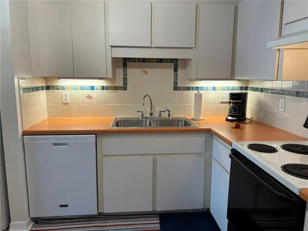 a kitchen with stainless steel appliances a stove a sink and a refrigerator