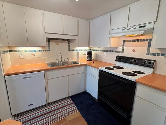 a kitchen with a stove top oven sink and cabinets