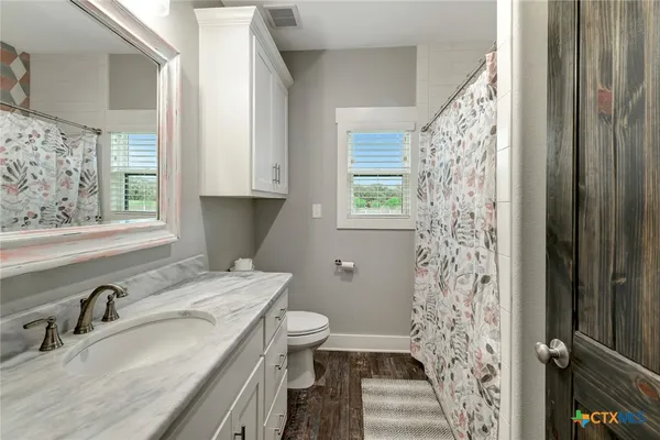 a bathroom with a granite countertop sink toilet and shower