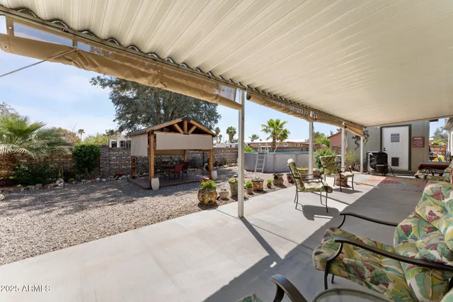 a view of a patio with couches and table and chairs with wooden fence