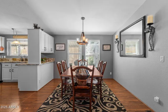 a dining room with furniture a chandelier and wooden floor