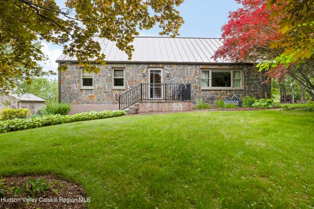 a front view of a house with a garden and yard
