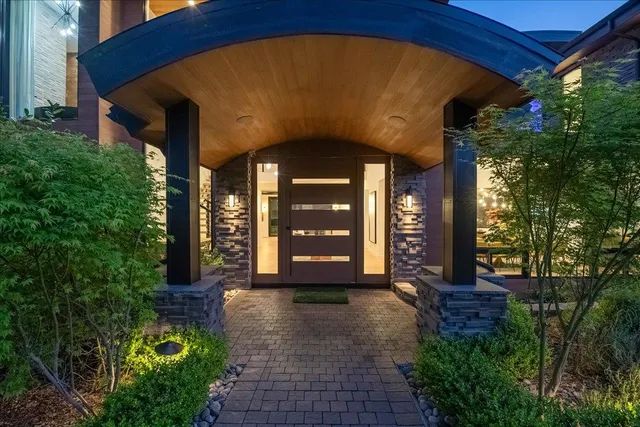 a front view of a house with a yard and potted plants