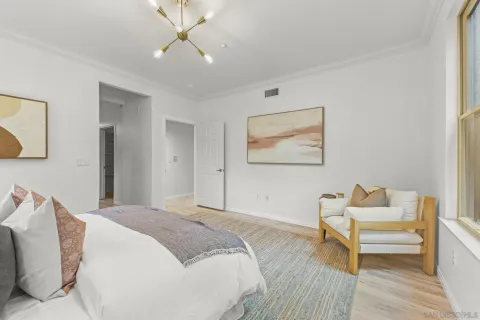 a spacious bedroom with a bed and a chandelier