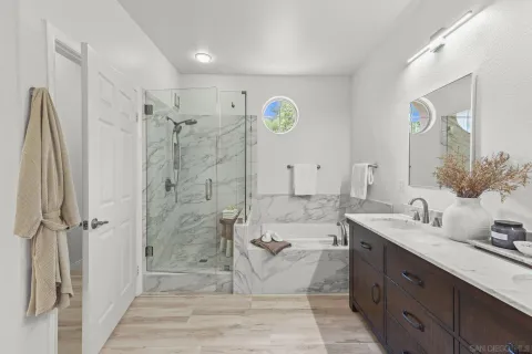 a spacious bathroom with a granite countertop sink a toilet a mirror and shower