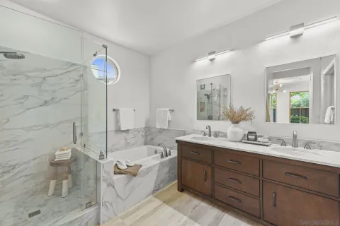 a bathroom with a granite countertop sink mirror and bathtub