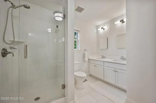 a spacious bathroom with a shower sink mirror and toilet