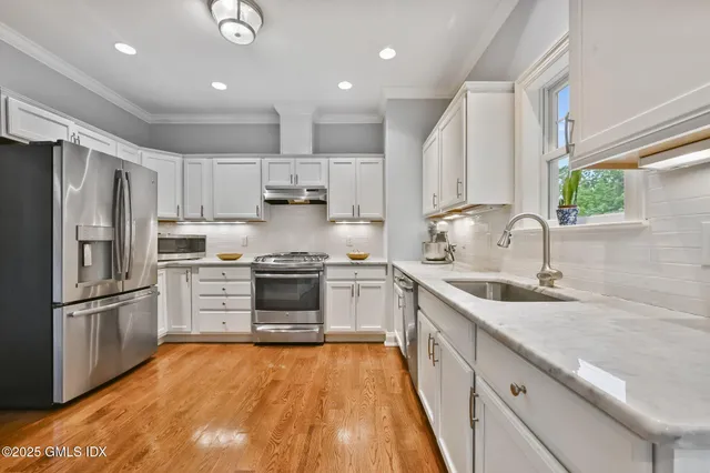 a kitchen with stainless steel appliances granite countertop a sink stove and refrigerator