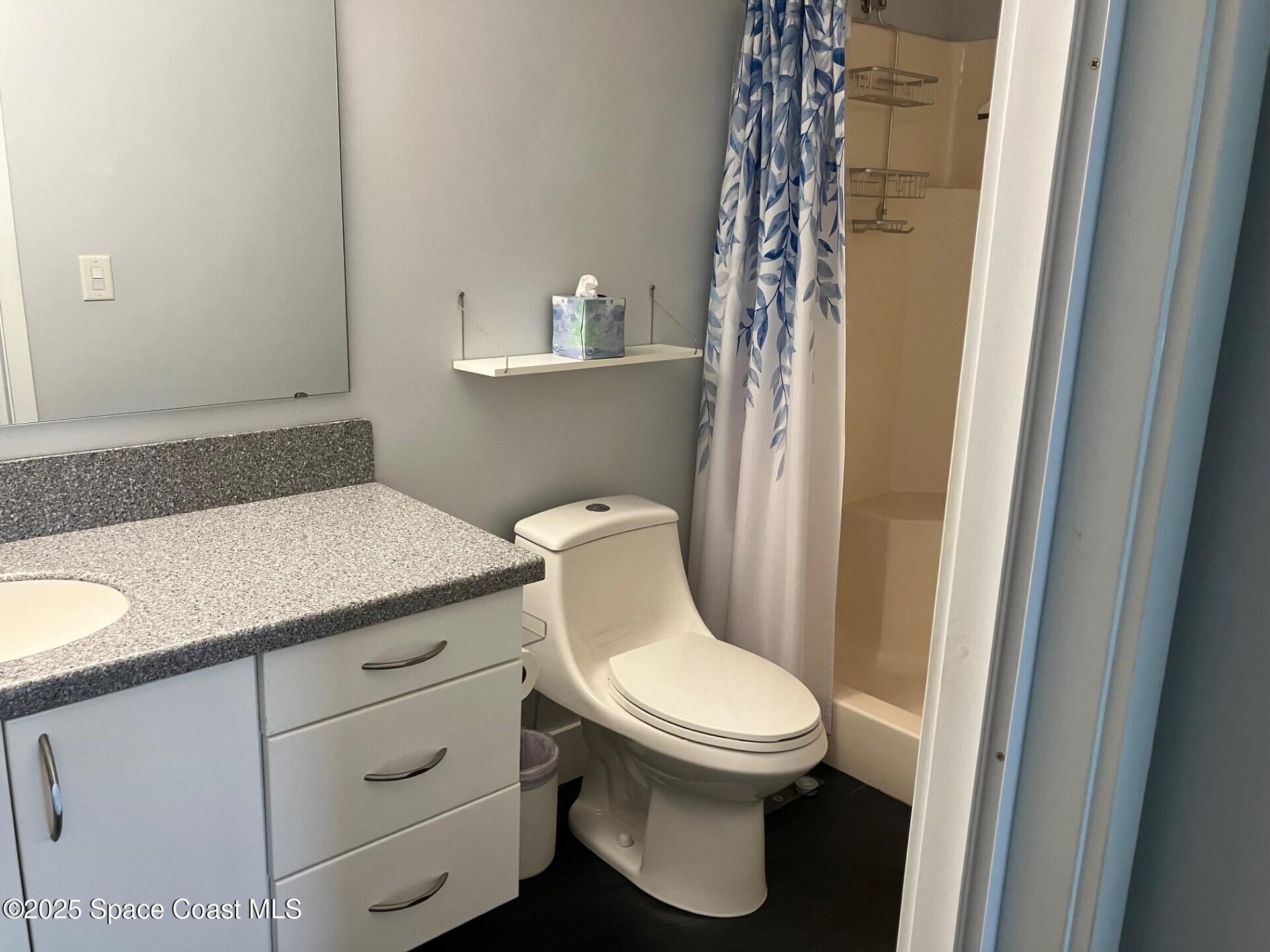 1420 Huntington Lane, Unit 2105 Rockledge, FL 32955 - Photo 13 of 24 a white toilet sitting next to a bathroom sink