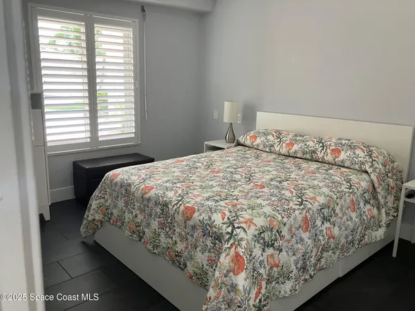 a bed sitting in a bedroom next to a window