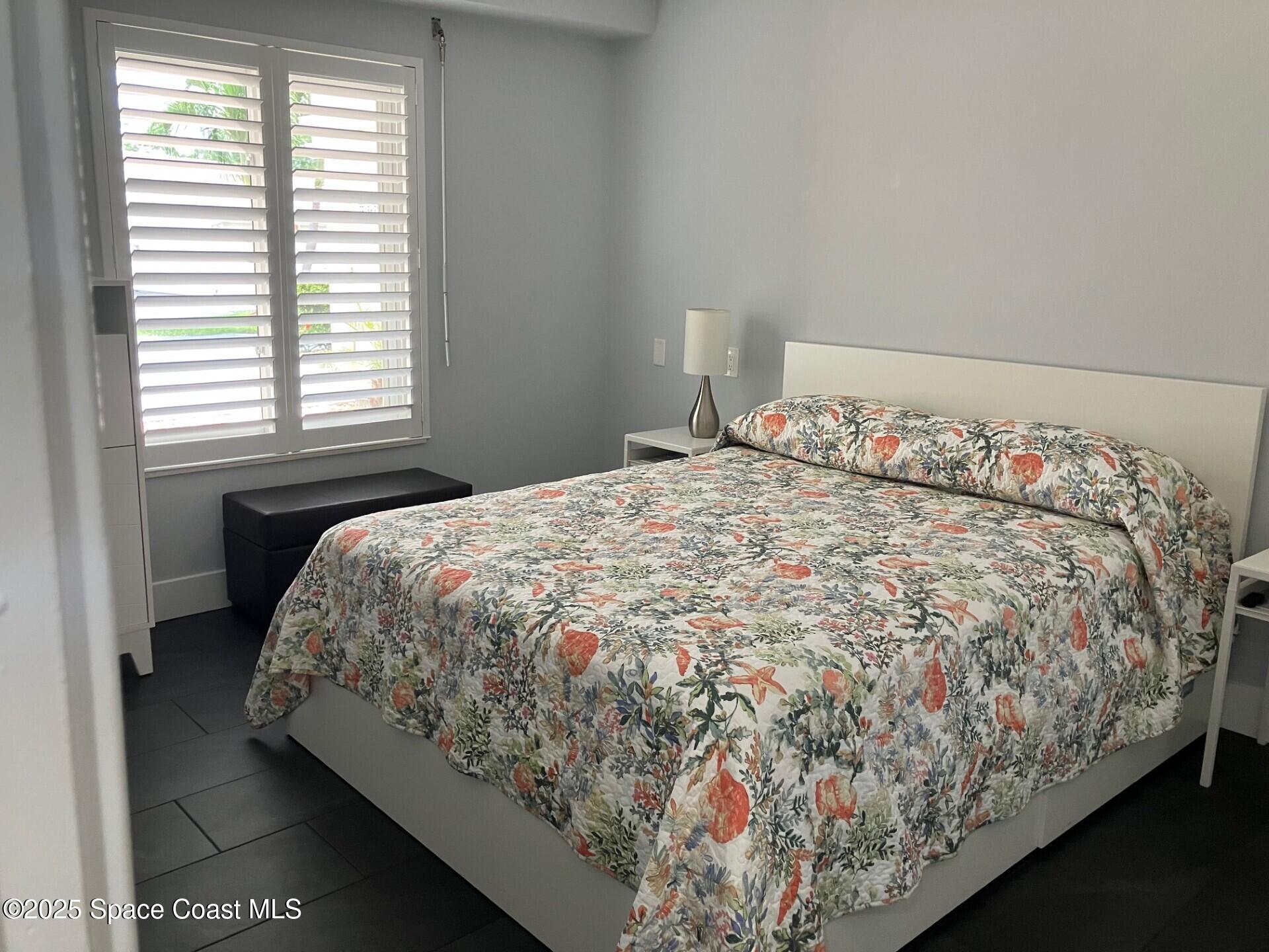 1420 Huntington Lane, Unit 2105 Rockledge, FL 32955 - Photo 9 of 24 a bed sitting in a bedroom next to a window