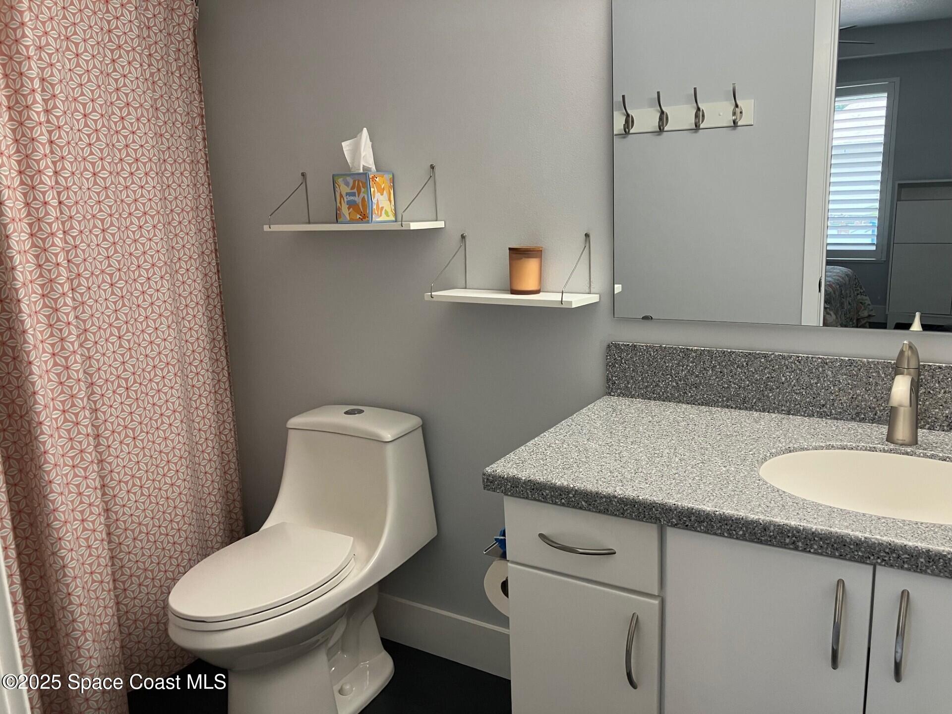1420 Huntington Lane, Unit 2105 Rockledge, FL 32955 - Photo 10 of 24 a bathroom with a toilet sink and mirror