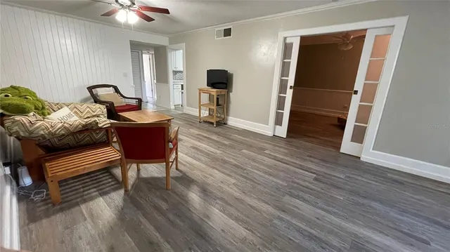 a view of a livingroom with a hardwood floor and a ceiling fan