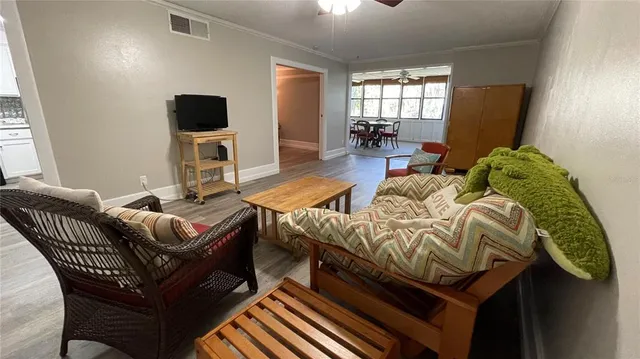 a view of a kitchen with refrigerator and wooden floor