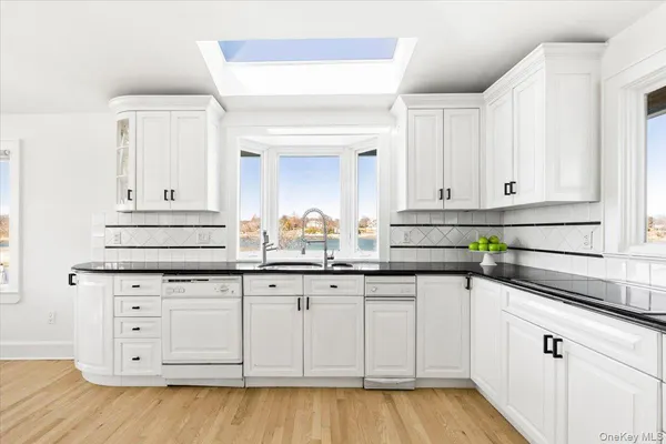 a kitchen with granite countertop white cabinets and a sink