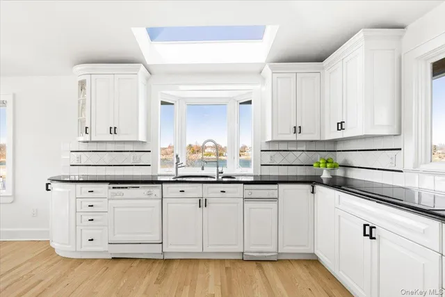 a kitchen with granite countertop white cabinets and a sink