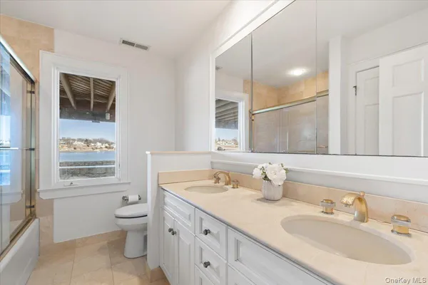 a bathroom with a granite countertop sink mirror and a toilet