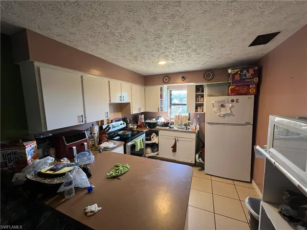 a room with furniture a flat screen tv and a refrigerator